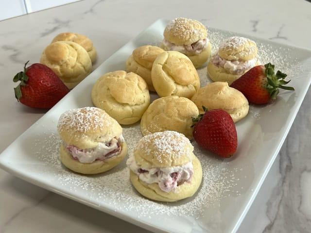 Deliciously light cream puffs filled with fresh whipping cream and strawberries.