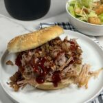 Garlic Bacon Pulled Pork Sandwich on a plate and served with a salad