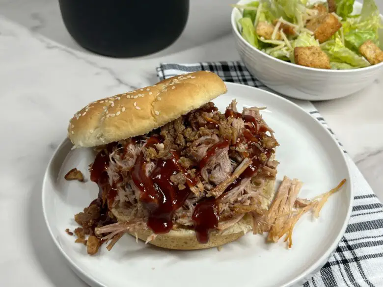 Garlic Bacon Pulled Pork Sandwich on a plate and served with a salad