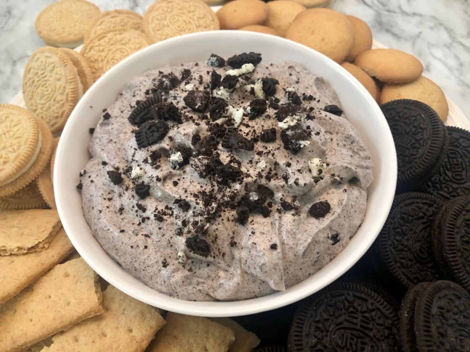 Thick and fluffy Oreo dessert dip with crushed cookies and cream cheese in a serving bowl.