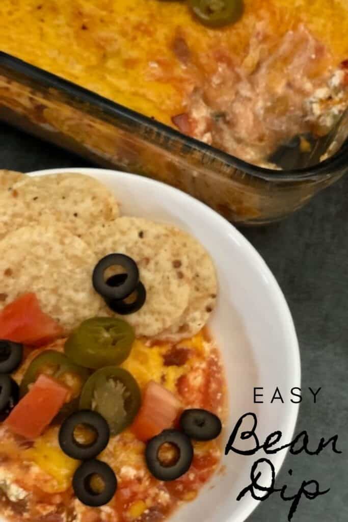 Easy Bean Dip is a quick and easy dip recipe that is perfect for parties or snacks. It is filled with yummy ingredients like, beans, green chilies,  salsa, sour cream and cheese. #BeanDip #MexicanRecipes #Snacks #Appetizers #PartyFood #NewYearsEve #DipRecipes