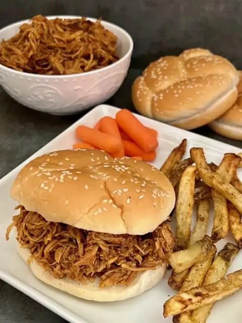 Shredded Asian Chicken is an easy and flavorful slow cooker chicken dinner recipe. #SlowCooker #Crockpot #ChickenDinner #Asian #HoisinSauce #MaePloy #ShreddedChickenSandwiches