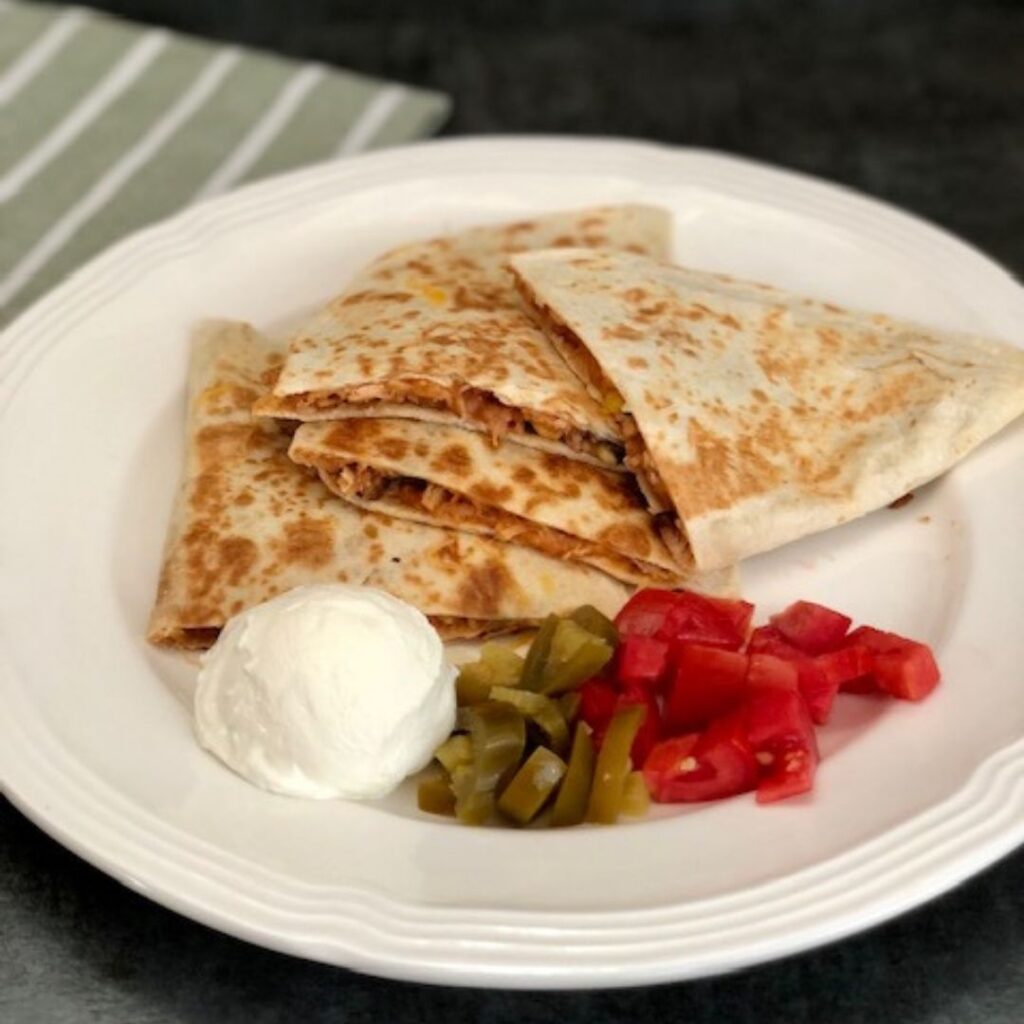 Barbecue Shredded Chicken Quesadillas are super easy to make and flavorful. This is an easy dinner recipe idea the whole family will love. #Quesadilla #ChickenRecipes #DinnerRecipes #RotisserieChicken #LunchIdeas #EasyDinners