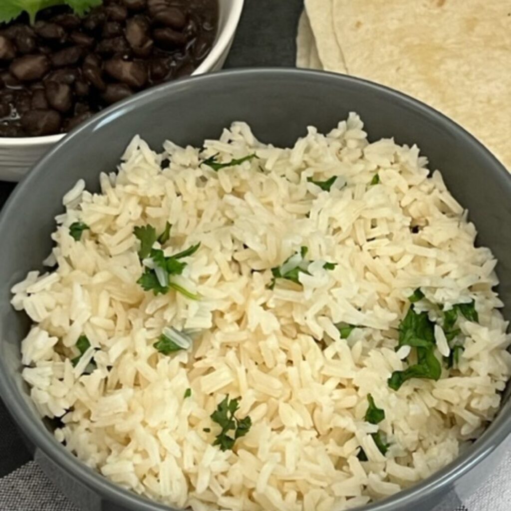 Instant Pot Cilantro Lime Rice is so easy and quick. The lime and cilantro flavors make this a perfect rice for burritos. #InstantPot #Rice #Sides #CopyCat #CafeRio