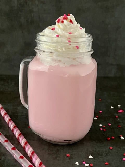 Strawberry White Chocolate Hot Cocoa is a fun and pretty Valentine's Day beverage. The kids will love the flavor, sprinkles and whipping cream. #Beverages #ValentinesDay #ValentinesRecipes #HotBeverageIdeas #Strawberry #WhiteChocolate #StephensHotCocoa #NesquikStrawberrySyrup