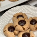 Chocolate Peanut Butter Thumbprint Cookies are cute and delicious! The soft peanut butter cookie is rolled in sugar and the middle is filled with a chocolate filling you will love! #ChocolateGanache #PeanutButterCookies #ChocolatePeanutButterCookies #ThumbprintCookies #PeanutButterBlossoms