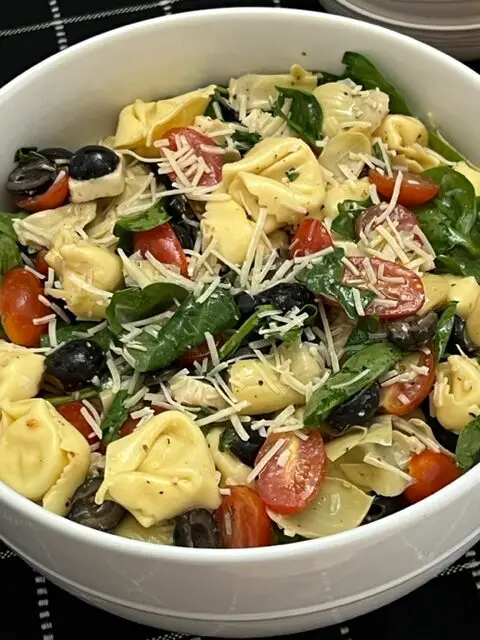 Tortellini Salad is a cold pasta salad filled with cheese tortellini, spinach, tomatoes, basil and more covered in a delicious dressing. #Tortellini #PastaSalads #SideRecipes #FourthOfJuly #BBQRecipes 