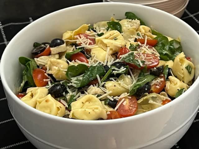Tortellini Salad is a cold pasta salad filled with cheese tortellini, spinach, tomatoes, basil and more covered in a delicious dressing. #Tortellini #PastaSalads #SideRecipes #FourthOfJuly #BBQRecipes