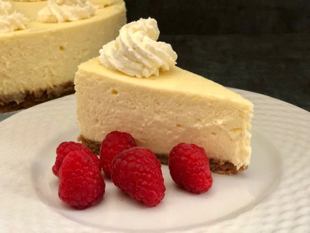 Vanilla Cheesecake is a classic dessert recipe. It is smooth and creamy and so versatile. Add raspberries, blueberries, blackberries, or other berries you like. It is also delicious with a raspberry sauce drizzled over the top. Also, it is great plain with a bit of whipping cream. #CheesecakeRecipes #DessertRecipes #VanillaCheesecake #HomemadeCheesecake