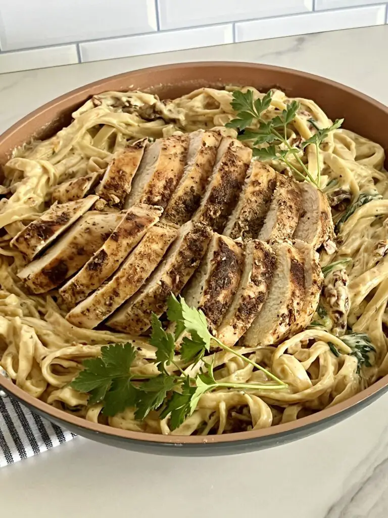 This Creamy Italian Chicken and Pasta dinner idea is a favorite comfort food recipe. The chicken is tender and flavorful. The creamy pasta sauce is full of sun dried tomatoes, baby spinach cream and parmesan cheese. #DinnerRecipes #ChickenRecipes #ItalianRecipes #ChickenDinner #Pasta #CreamyPastaSauce #CreamyItalianChickenandPasta