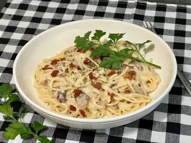 A delicious and easy pasta with bacon, onion, mushrooms and a creamy sauce.