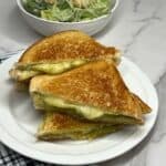 Grilled cheese sandwich with smoked gouda and basil pesto and parmesan cheese. Serve with a side salad.