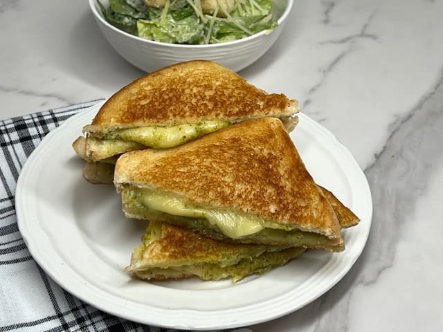 Grilled cheese sandwich with smoked gouda and basil pesto and parmesan cheese. Serve with a side salad.
