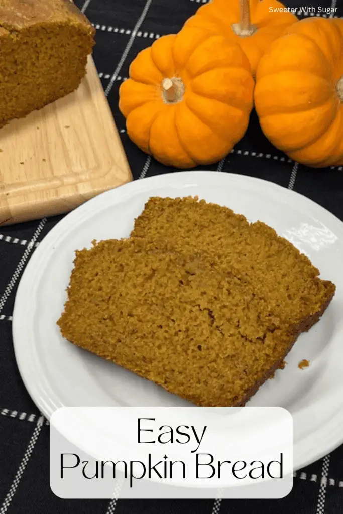 A freshly baked loaf of homemade pumpkin bread sliced to reveal its moist, golden-orange interior on a cutting board with little pumpkins. #PumpkinBread #FallBaking #PumpkinSpice #EasyBaking #MoistPumpkinBread #HomemadeBread #BakingFromScratch