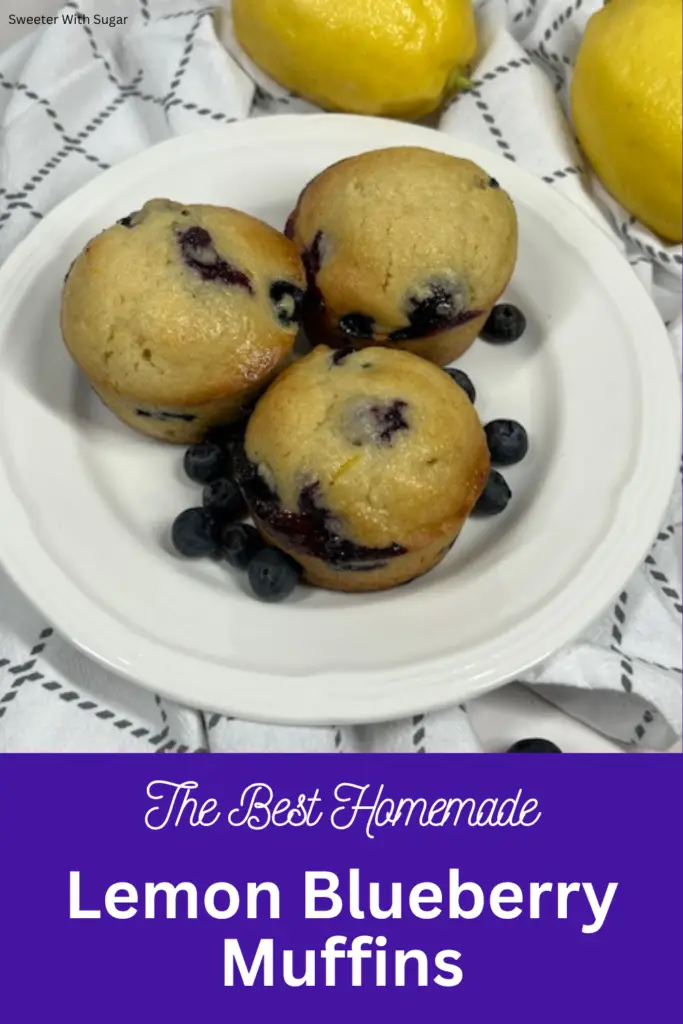 Close up of fluffy lemon blueberry muffins with golden tops and fresh blueberries.