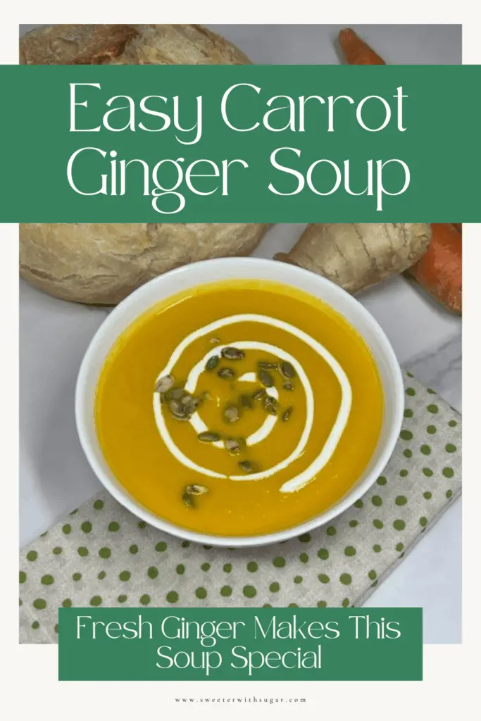 Homemade carrot ginger soup with a smooth orange texture, topped with pumpkin seeds and served with bread.