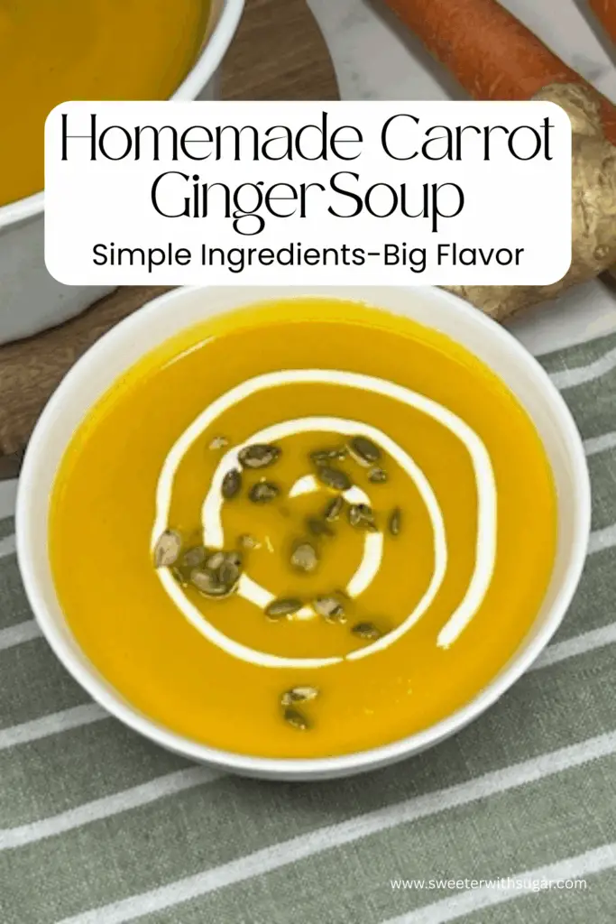 Homemade carrot ginger soup blended until smooth and served in a white bowl with crusty bread.