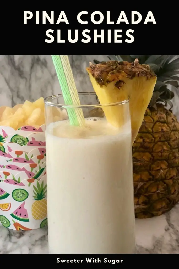 A Pina Colada Slushie in a tall glass with a slice of fresh pineapple.